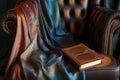 silk scarf and leatherbound journal arranged artistically on leather armchair