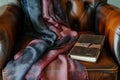 silk scarf and leatherbound journal arranged artistically on leather armchair