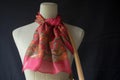 silk scarf tied to a mannequins handbag handle