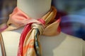 silk scarf tied to a mannequins handbag handle