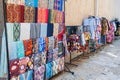 silk scarves, fabric bags and dresses with a traditional bright colorful Asian pattern at oriental bazaar in Uzbekistan