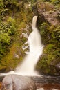 Silky forest waterfall cascading down rocky slope