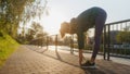 Sillhouette of attractive young woman stretching before her early morning run along the embankment of river. Royalty Free Stock Photo