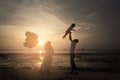 Sillhouette of happy asian family having fun time at the beach with sunset view as background