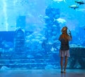 Sillouette of the woman taking picture in large aquarium