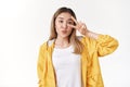 Silly cheerful feminine asian teenage female pouting folding lips cute show victory peace gesture near eye taking