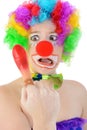 Silly clown made up in costume for carnival or halloween shows up his red painful finger