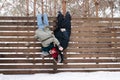 Silly couple kissing while hanging upside down from a wooden fence Royalty Free Stock Photo