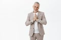 Silly cute and tender senior male father in formal suit with grey hair and beard tilting head like puppy holding hands Royalty Free Stock Photo