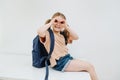 Silly little girl having fun, grimacing, making googles gesture. Over white