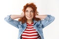 Silly playful good-looking redhead girl curly hairstyle close ears press hands head look up delighted smirking standing