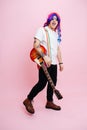 Silly rock musician posing with his instrument. Over pink background Royalty Free Stock Photo