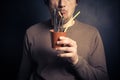 Silly young man drinking from leather cup with straws