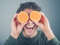 Silly young man using oranges as binoculars Royalty Free Stock Photo