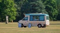 Ice Cream van parked in park land with no customers on a sunny day.