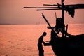 Siluet of Fisherman Preparing His Boat for Fishing at Dusk Time