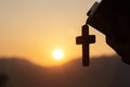 Siluette of Christian woman  holding a bible and wooden Christian cross necklace while praying to God Royalty Free Stock Photo