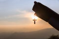 Siluette of Christian woman  holding a bible and wooden Christian cross necklace while praying to God Royalty Free Stock Photo