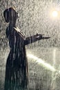 Siluette of a woman under artificial rain in rain room Royalty Free Stock Photo