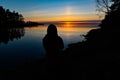 Siluette of a young person standing infront of a sunset