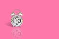 Silver alarm clock isolated on pink background. Royalty Free Stock Photo