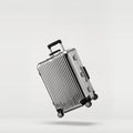 Silver aluminum suitcase levitates on white. Royalty Free Stock Photo