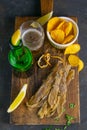 Silver Amber Fish with pepper with beer, lemon and potato chips on dark wooden board. Snack on fish with beer. Top views, close-up