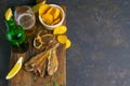 Silver Amber Fish with pepper with beer, lemon and potato chips on dark wooden board. Snack on fish with beer. Top views with