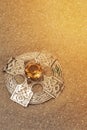 Silver antique old Celtic brooch with amber gemstone in sand.