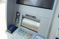 Silver automatic teller machine hanging on a gray concrete wall Royalty Free Stock Photo