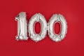 Silver 100 balloons on wine red matt background Royalty Free Stock Photo