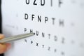 Silver ballpoint pen pointing to letter in eyesight check table