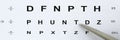 Silver ballpoint pen pointing to letter in eyesight check table