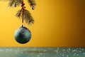 Silver bauble hanging on a Christmas tree branch on the left. Gold background. Side view.Christmas banner with space for your own Royalty Free Stock Photo