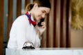 Silver bell on hotel reception service desk with blurred background of smiling Asian female receptionist talks to customer guest Royalty Free Stock Photo