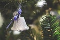 Silver bells with blue satin ribbon bow hang on the Christmas tree Royalty Free Stock Photo