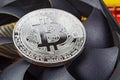 Silver bitcoin on the central processing unit fan background closeup. Cryptocurrency virtual money Royalty Free Stock Photo