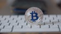 Silver bitcoin cymbol on keyboard. Selective focus.