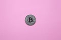 Silver bitcoin on a millennial pink background. Top view. Minimalism. Horizontal orientation. Flat lay