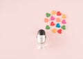 A silver black microphone next to which are hearts of different colors. Minimal concept of spreading love, positive thoughts and