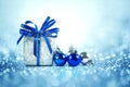 Silver and blue Christmas balls and gifts on cool glitter lighting background