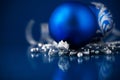 Silver and blue christmas ornaments on dark blue background. Royalty Free Stock Photo