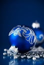 Silver and blue christmas ornaments on dark blue background with space for text. Royalty Free Stock Photo