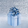 Silver blue gift box with ribbon over blurred shiny background