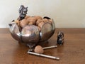 Silver Bowl Containing Mixed Nuts with Shells with a Walnut and Nutcracker in Foreground Royalty Free Stock Photo