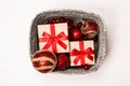 Silver box with presents and red christmas balls on white wooden background. Royalty Free Stock Photo