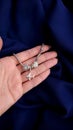 Silver bracelet with charms on a beautiful female hand on a dark blue fabric background Royalty Free Stock Photo