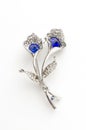 Silver brooch flower with blue stone isolated on white Royalty Free Stock Photo