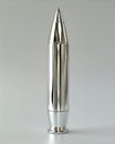 A silver bullet shaped object on a gray surface Royalty Free Stock Photo