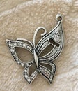 Silver Butterfly Pendant with Shiny Clear Rhinestones on Textured Background